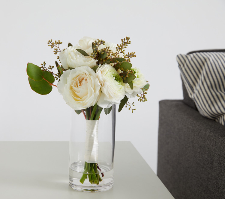 A vase of flowers next to a couch